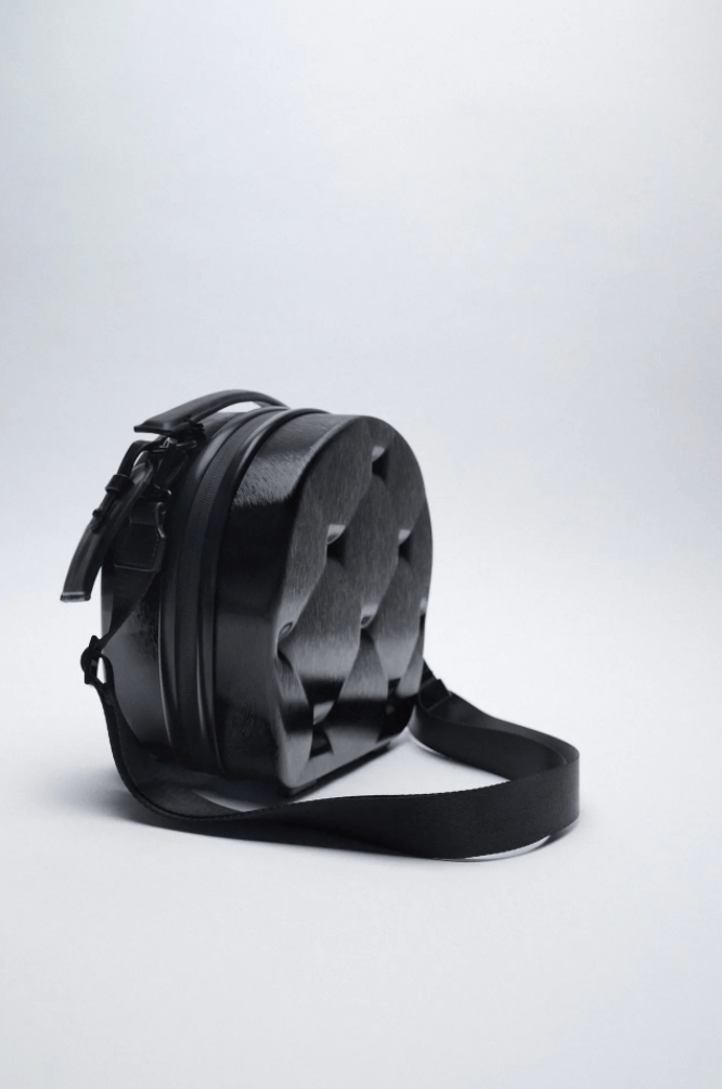 ZARA貝殼手提包呈圓形,不過底部設計成平平的,方便放在行李箱上。