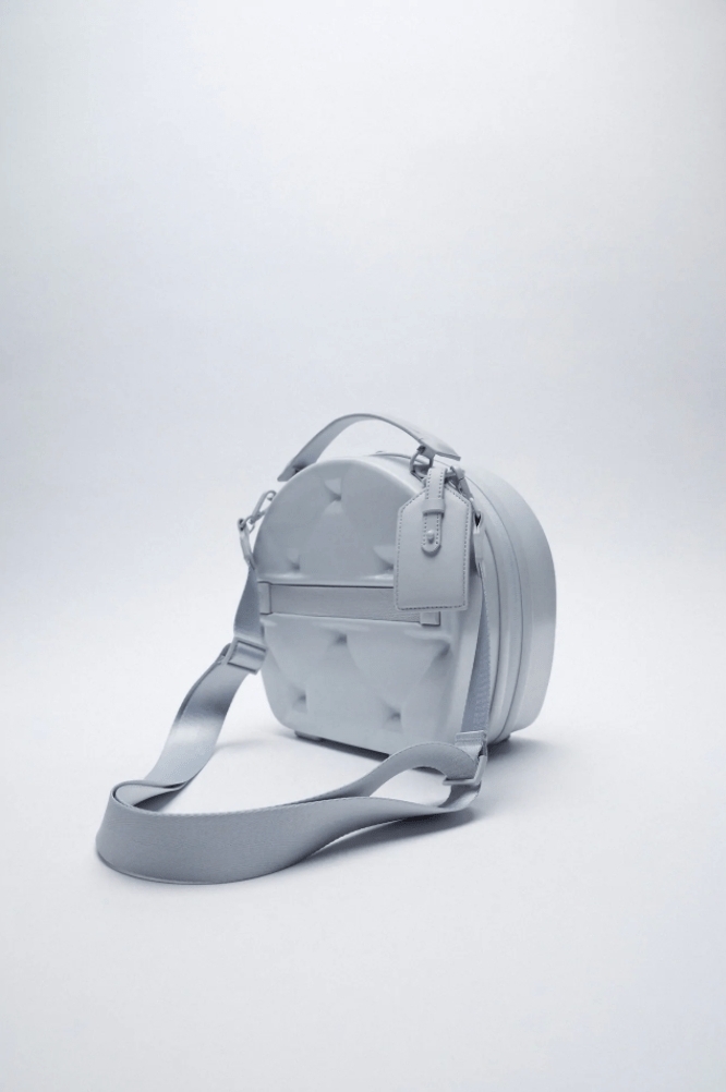 ZARA貝殼手提包背面設有一條掛在行李箱手柄的拉帶,也綁有一個超美的行李牌在旁邊,有滿滿的歐美風。